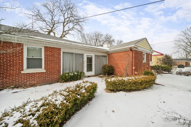 view of front of property with brick siding and a chimney