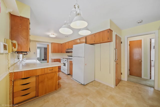 kitchen featuring decorative light fixtures, light countertops, brown cabinetry, white appliances, and under cabinet range hood