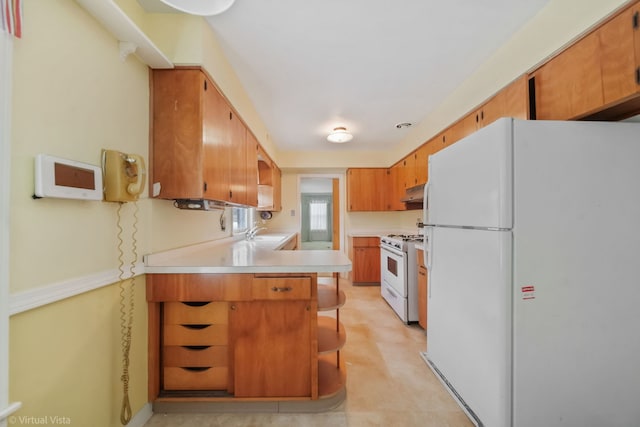 kitchen featuring under cabinet range hood, a peninsula, white appliances, a sink, and light countertops