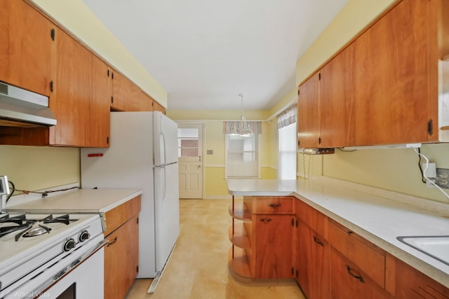 kitchen with brown cabinets, white appliances, pendant lighting, and light countertops