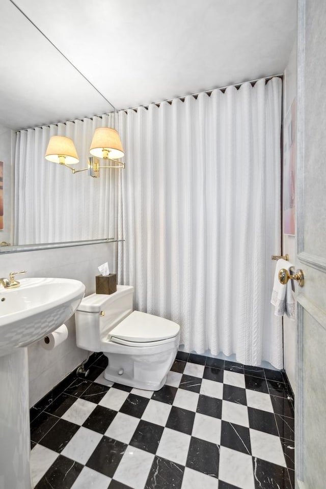 bathroom featuring a sink, toilet, and tile patterned floors