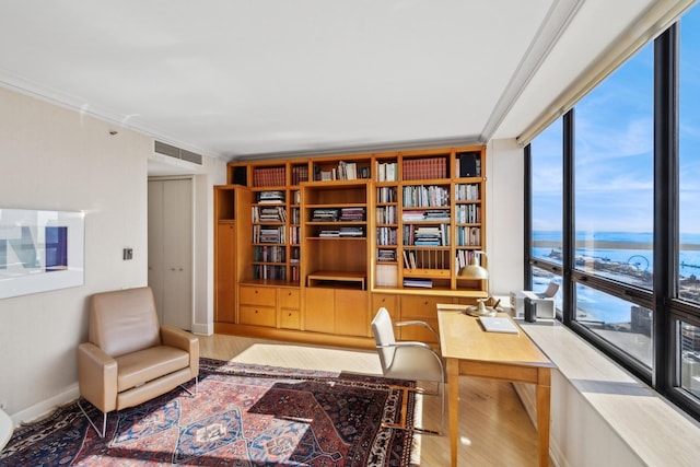 office area with visible vents, crown molding, light wood finished floors, and built in study area