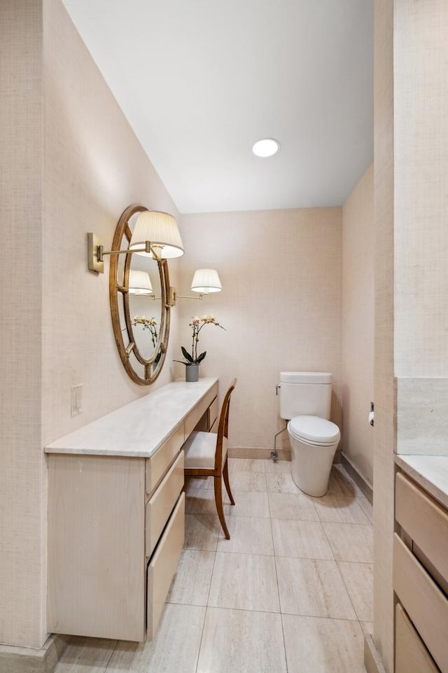 half bathroom with tile patterned flooring, vanity, and toilet