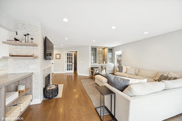 living room with recessed lighting, a fireplace, baseboards, and wood finished floors