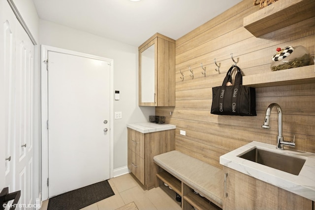mudroom featuring light tile patterned flooring and a sink