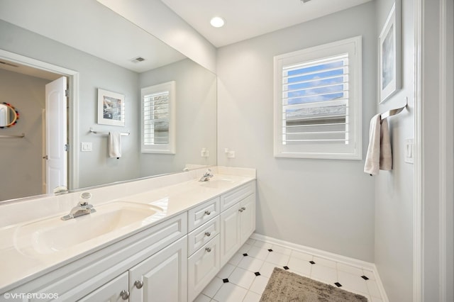 full bathroom with double vanity, a sink, visible vents, and baseboards