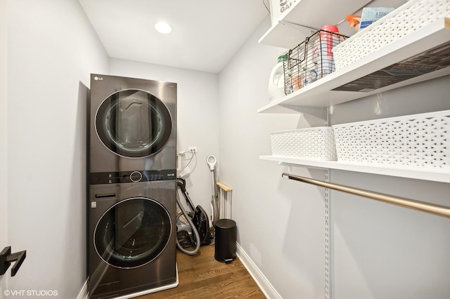 laundry room featuring recessed lighting, stacked washer and dryer, laundry area, wood finished floors, and baseboards