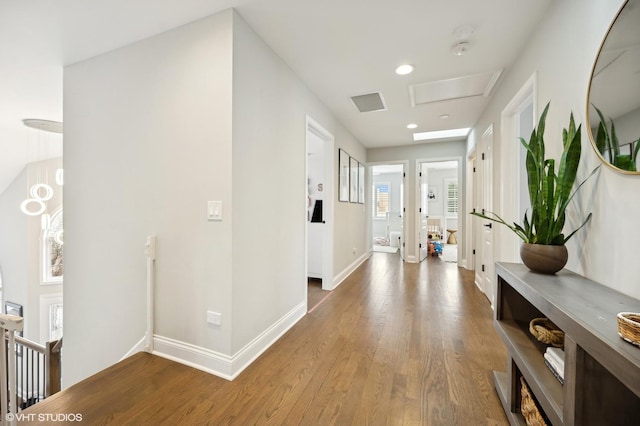 hall featuring recessed lighting, wood finished floors, visible vents, an upstairs landing, and baseboards