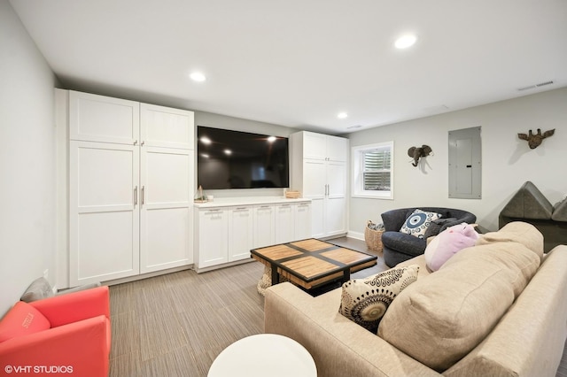 living area with electric panel, visible vents, and recessed lighting
