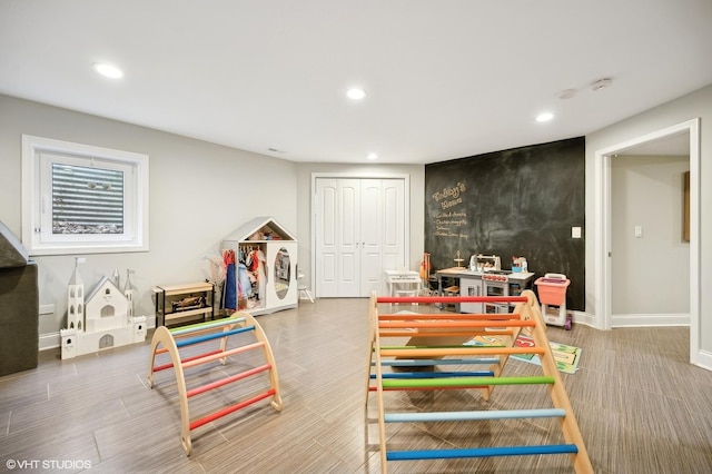 rec room with an accent wall, baseboards, and recessed lighting