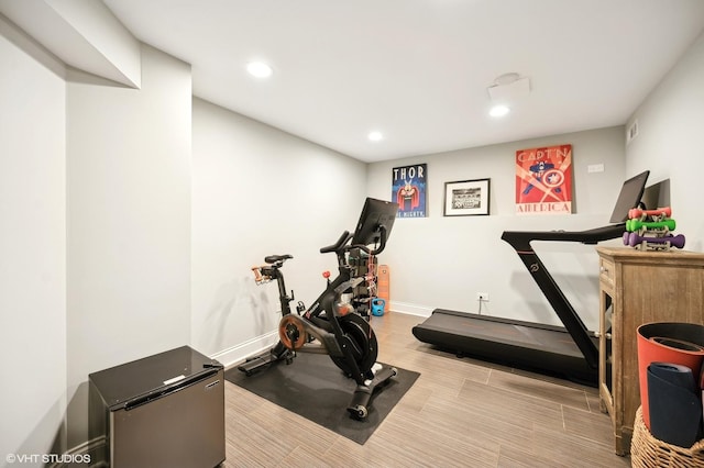 workout area featuring baseboards, wood finished floors, and recessed lighting