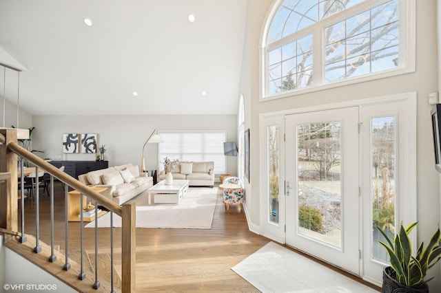 interior space with a towering ceiling, stairs, wood finished floors, and recessed lighting