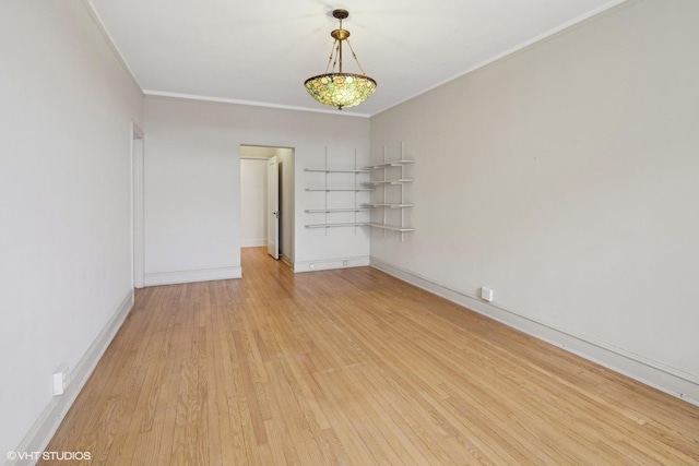 empty room featuring crown molding and light hardwood / wood-style floors