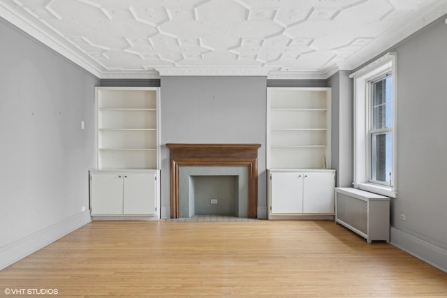 unfurnished living room with ornamental molding, radiator heating unit, and light hardwood / wood-style floors