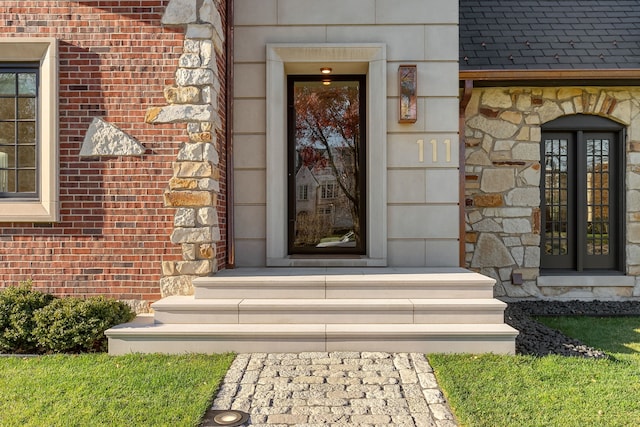 doorway to property with stone siding and brick siding