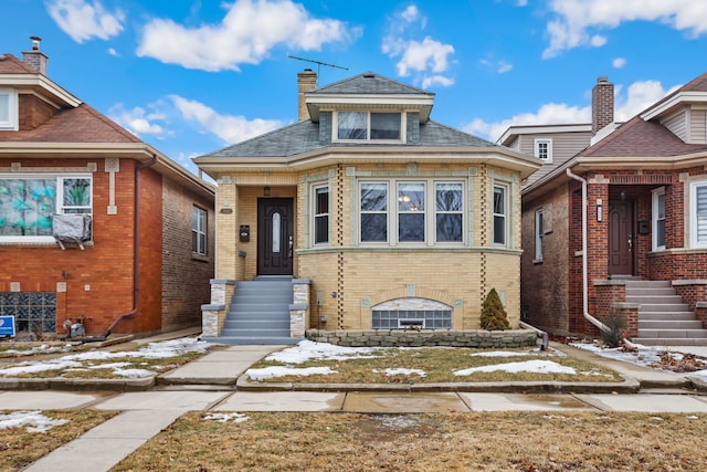 view of front of house featuring a chimney and brick siding