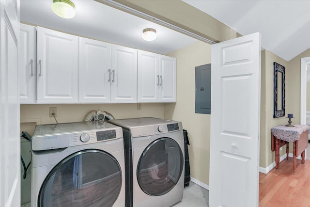 laundry area with baseboards, cabinet space, electric panel, light wood finished floors, and washing machine and clothes dryer