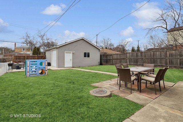 view of yard with a patio area, a fenced backyard, outdoor dining area, and an outdoor structure