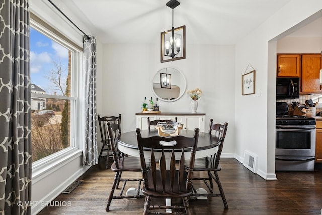 dining area featuring dark wood-style floors, visible vents, a notable chandelier, and baseboards