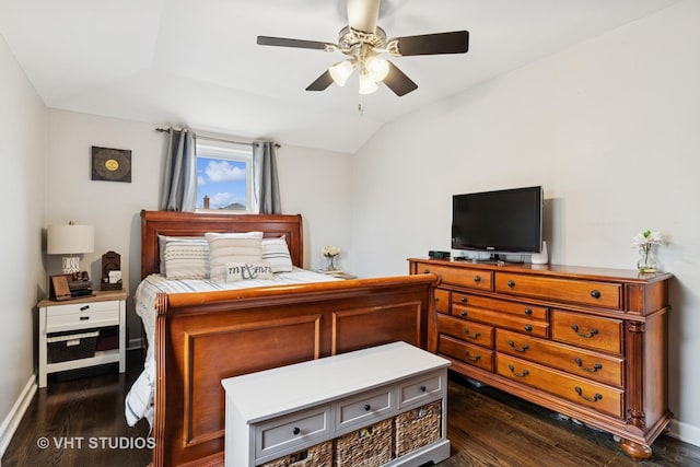 bedroom with vaulted ceiling, dark wood-type flooring, a ceiling fan, and baseboards