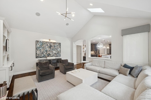 living room with light wood finished floors, a chandelier, arched walkways, and high vaulted ceiling