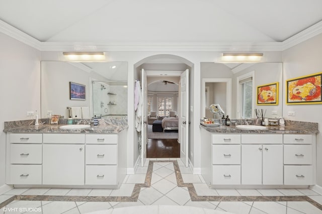 ensuite bathroom featuring vaulted ceiling, ornamental molding, ensuite bath, and a shower stall