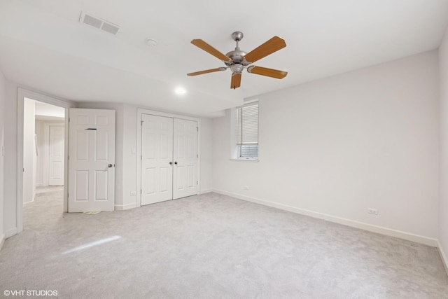 unfurnished bedroom featuring light carpet, a closet, visible vents, and baseboards