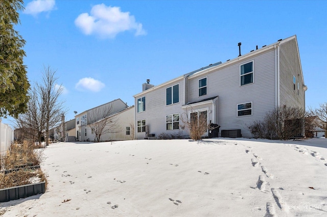 view of snow covered rear of property