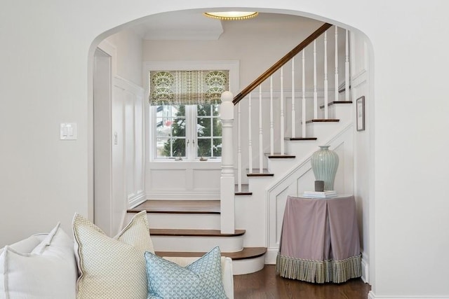 interior space with arched walkways and wood finished floors