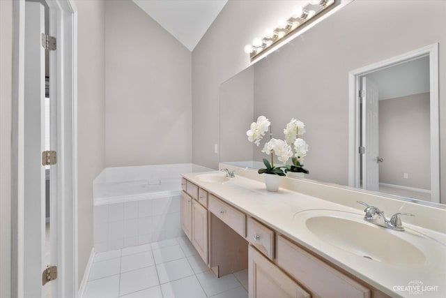 bathroom with tile patterned floors, double vanity, a bath, and a sink