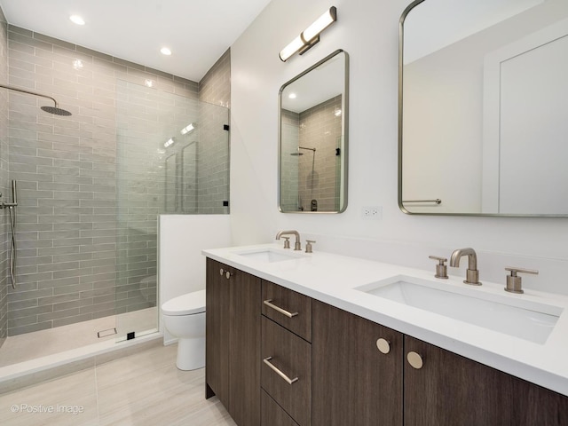 bathroom with tiled shower, vanity, toilet, and tile patterned flooring