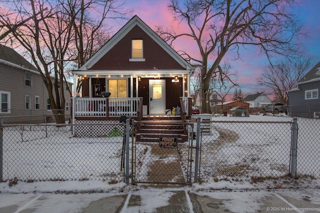 bungalow-style home featuring a fenced front yard, a gate, and a porch