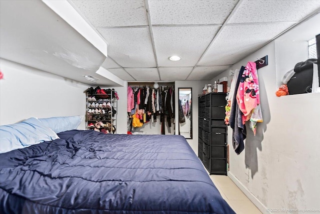 bedroom with baseboards and a drop ceiling