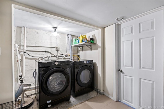 washroom featuring light tile patterned floors, laundry area, separate washer and dryer, and baseboards