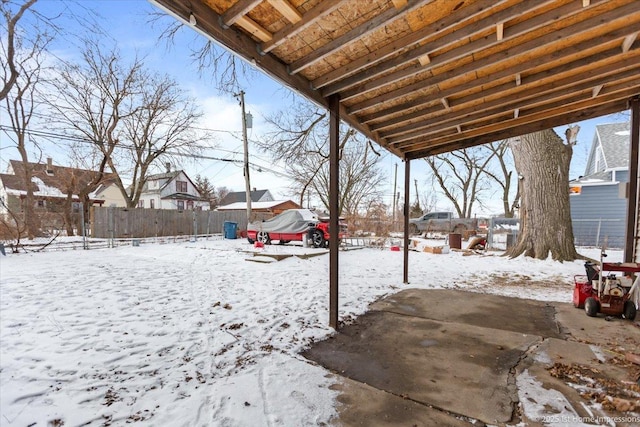 yard covered in snow with fence and a residential view