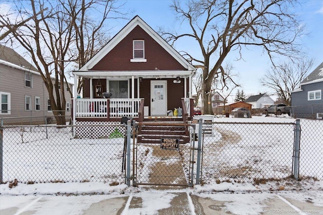 bungalow-style home with a fenced front yard, a gate, and a porch