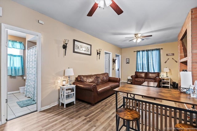 living area with plenty of natural light, baseboards, and wood finished floors