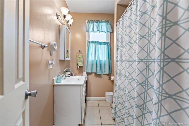 bathroom with tile patterned flooring, baseboards, and vanity