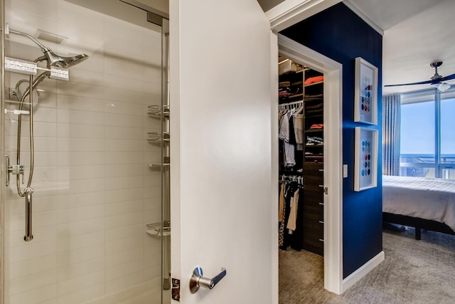 full bathroom featuring a spacious closet, a stall shower, ensuite bath, and a ceiling fan