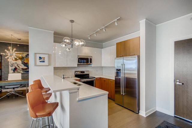 kitchen with stainless steel appliances, light countertops, a chandelier, and white cabinets