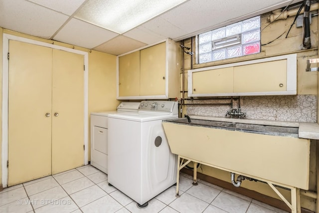 laundry room with washing machine and dryer, cabinet space, and light tile patterned floors