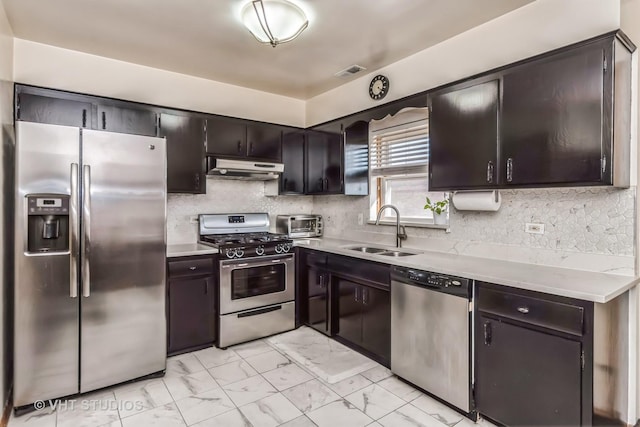 kitchen with visible vents, appliances with stainless steel finishes, marble finish floor, under cabinet range hood, and a sink