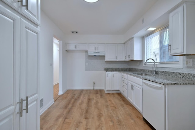 kitchen featuring sink, dishwasher, white cabinets, light stone countertops, and decorative backsplash