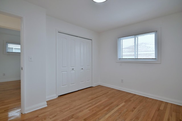 unfurnished bedroom with light wood-type flooring and a closet