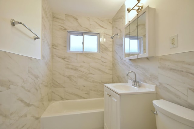 full bathroom featuring tile walls, vanity, tiled shower / bath, and toilet