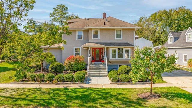 view of front facade featuring a chimney, a front lawn, and stucco siding