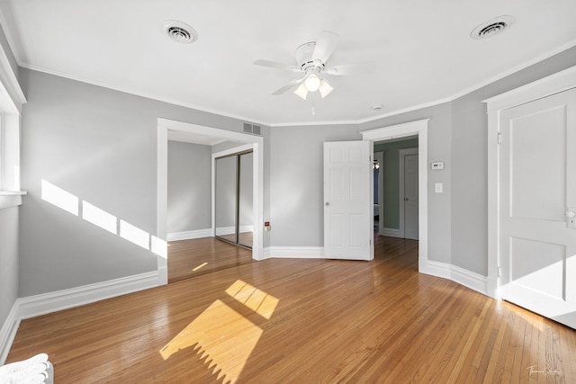 unfurnished bedroom with light wood-style flooring, a closet, and visible vents