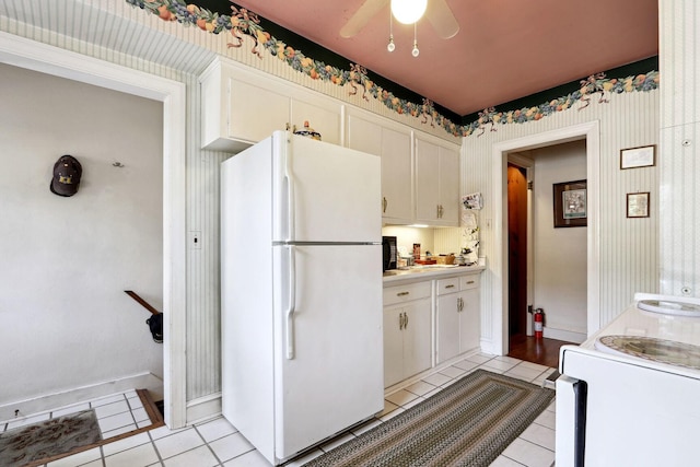 kitchen featuring white appliances, light tile patterned floors, ceiling fan, and white cabinets