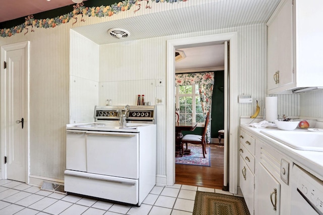 kitchen featuring white appliances, light tile patterned floors, sink, and white cabinets