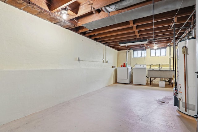 basement featuring sink, gas water heater, and washing machine and clothes dryer